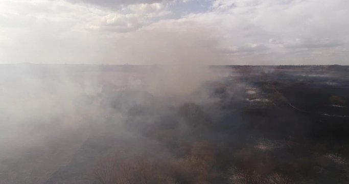 Aerial view shot through smoke from burning field