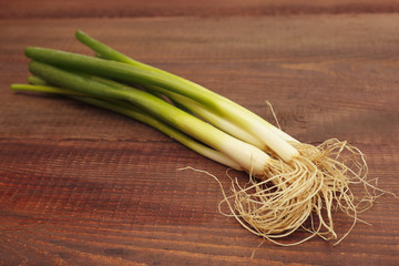 Bunch of fresh leeks on a rustic wooden table.