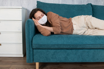 Woman sleeping on sofa in medical mask during home stay in self-isolation quarantine