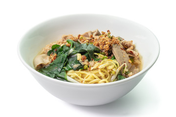 The close up of Thai Tom Yum Spicy Noodle with ivy gourd leaves on white bowl.