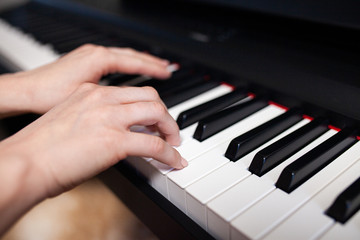 Fototapeta na wymiar Woman hand's playing on the piano close up