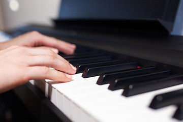 Fototapeta na wymiar Woman hand's playing on the piano close up