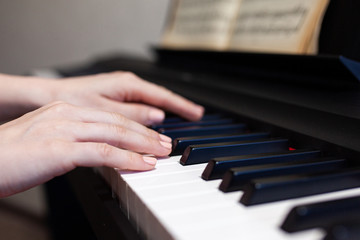 Obraz premium Woman hand's playing on the piano close up