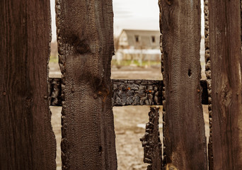 Burnt fence boards after a fire in a private house.
