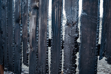 Burnt fence boards after a fire in a private house.