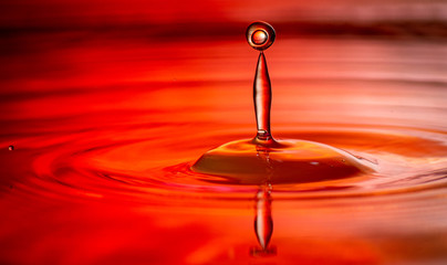 Wasser tropfen auf wasser rot Hintergrund beleuchtung mit kleinen wellen 