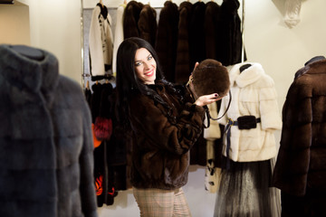 Winter beautiful Woman in Fur Coat. Beauty Fashion Model Girl In a Fur Store.