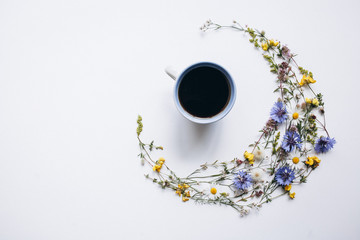 coffee cup and wildflowers on white background