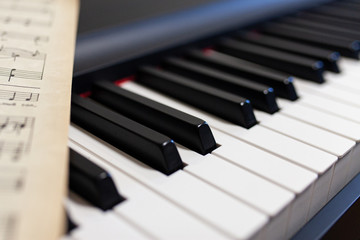Piano and vintage music sheets close up