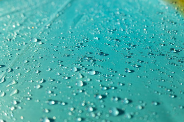 Naklejka na ściany i meble Detail of water drops on a plastic fabric colored in the sun.