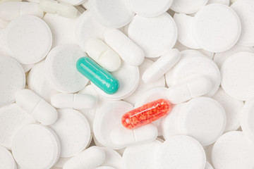 colorful pills between a lot of white pills