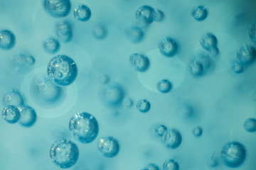 Many round bubbles of the shower gel on the blue background.
