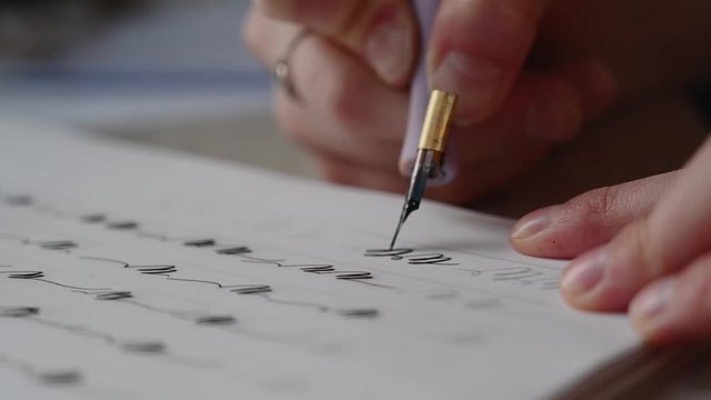 a girl fills a calligraphy notebook with beautiful symbols