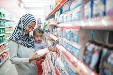 muslim asian Mother hijab and baby shopping in the supermarket. grocery store shopping