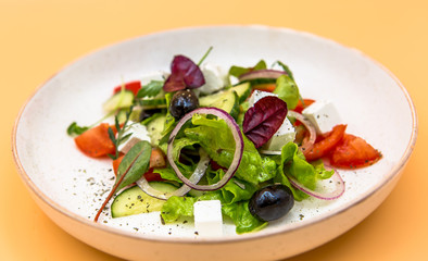 Salad of greens, red onions, slices of cheese and olives