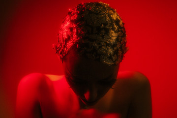 Portrait of a woman in red lights looking down