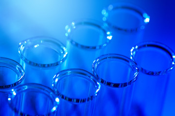 Test tube row. Concept of medical or science laboratory, liquid drop droplet with dropper in blue tone background, close up, micro photography picture.