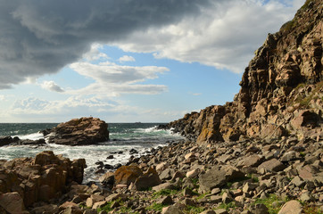Fototapeta na wymiar The rocky coastline and cloudy sky