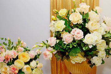 Bouquets of roses on a light background in a Golden vase, a large number of roses, floral mood