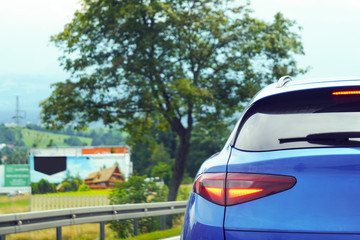Led tail light of a blue car, luxury. A blue car behind a country road. Traffic outside the city.