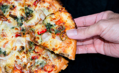 Hand hold slice of hot fresh veggie pizza cheese fast food, Delicious taste fresh veggie pizza with spinach, tomatoes, onions, mushrooms, red peppers, green peppers, Gouda cheese, mozzarella cheese, 