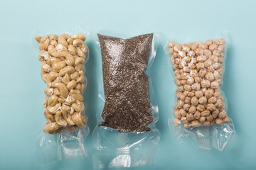 Vacuum plastic bag of  .cashew nuts, chia seeds, chickpea, isolated on blue