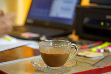 coffee cup is located on the desk that the employees work from home.