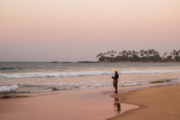 Fototapeta na wymiar Native fisherman on the beach at down. Sri lanka