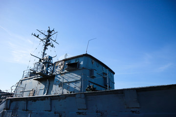 old abandoned military ship superstructure close up with blue sky on the background