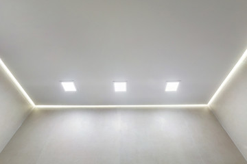 suspended ceiling with halogen spots lamps and drywall construction in empty room in apartment or...