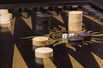 Backgammon. Board game. White cubes and chips on a blackboard.  Dice on backgammon board game. Selective focus. Playing leisure games