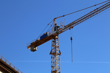 Naklejka premium Crane at a construction site on a background of blue sky