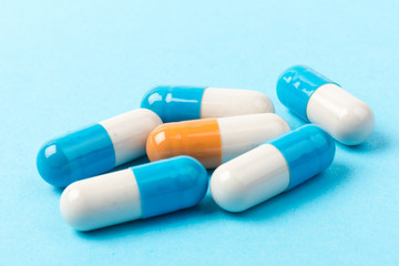 Pills isolated on blue background.Colorful medical drug capsule.