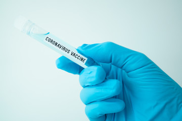 Obraz premium scientist holding test tube with covid-19 or coronavirus vaccine label, lab testing for inventing pandemic medication