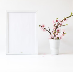 Flowers composition spring. Blank photo frame for text and peach blossom