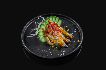 Classic raw eel sashimi with daicon raddish on a stylish black ceramic plate on a black background. Japanese traditional food. Photo for the menu