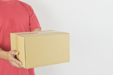 Delivery services concept. Delivery man holding parcel box for customer services on grey background.