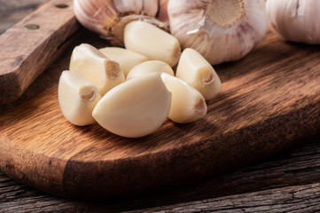 Sliced Garlic and garlic bulb on vintage wooden background. Place for text, copy space. Concept of healthy food.