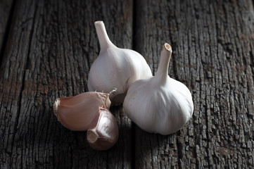 Garlic clove and garlic bulb on vintage wooden background. Place for text, copy space. Concept of healthy food.