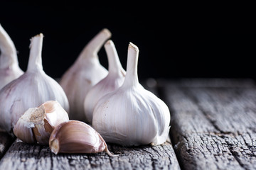 Sliced Garlic and garlic bulb on vintage wooden background. Place for text, copy space. Concept of healthy food.