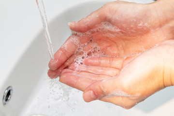 Fototapeta premium woman washes hands under the tap close up