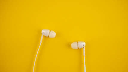 white headphones on a yellow background