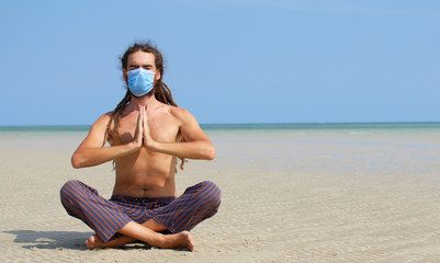COVID-19 epidemic, a man in a surgical mask meditates, keep calm and hygiene