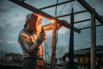 masked welder at hazardous work