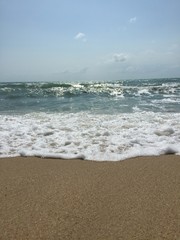 the sun shines on the blue sea and the sandy beach against the blue sky