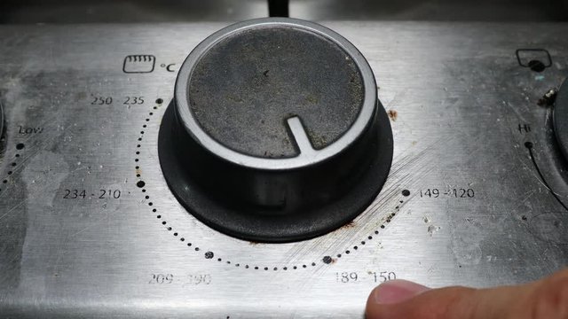 turning the knob on the stove for baking
