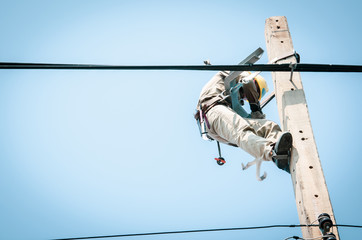 Electricians are climbing on electric poles to install and repair power lines.