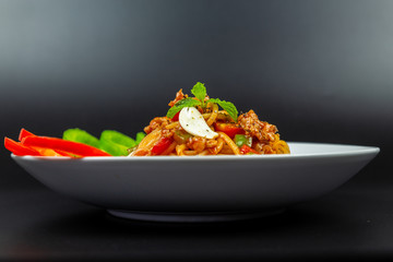 Delicious Spaghetti on plate. Delicious Spaghetti with tomato sauce. Spaghetti Isolated on black background. Pasta with cherry tomatoes.Italian Food.