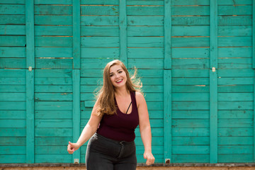 Young stylish woman walking in the city street. Spring fashion outfit, elegant look. Plus size model.