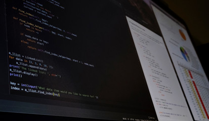 Close view of a computer screen with programming code and charts about coronavirus crisis evolution